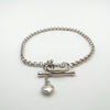 T-bar clasp and heart charm detail on sterling silver bracelet