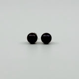 Close up of dark cultured black pearl stud earrings showing the rounded 8mm pearl fronts