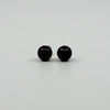 Close up of dark cultured black pearl stud earrings showing the rounded 8mm pearl fronts