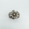 Top view of sterling silver ring with textured 3D flower and patina finish