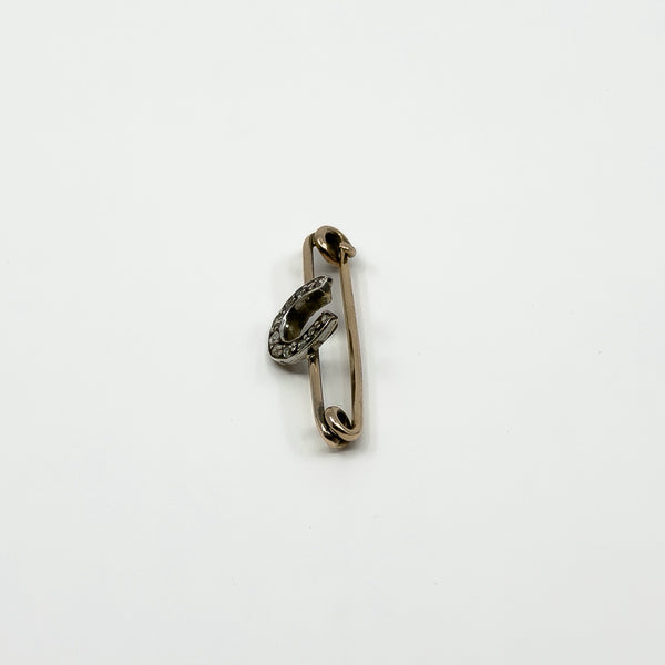 Angled side view of antique diamond horseshoe brooch with 9ct gold bar and silver setting