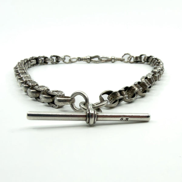 Close-up of one dog clip fitting on the sterling silver Albert chain, showing wear and construction.