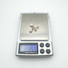 Digital scale showing total earring weight of 1.55g