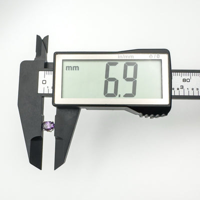 Digital caliper measuring amethyst stud earring length at 6.9mm