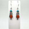 Turquoise and coral sterling silver earrings on display stand, shepherd hook