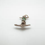 Low angle showing the engraved gold fluke and jade centre of the pendant
