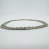 Close-up showing engine-turned textured bar links on silver chain