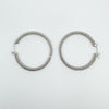 CZ full hoop earrings laid flat on a white background, full view of design