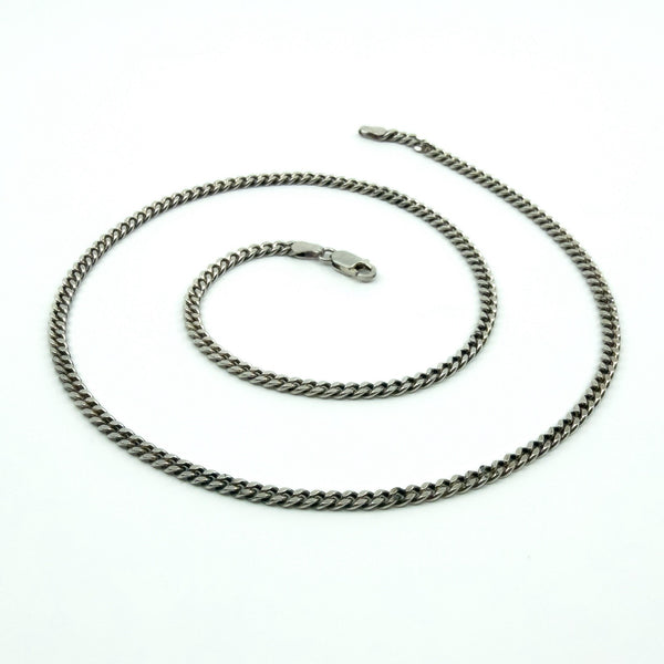 Full length view of the sterling silver flat curb chain with lobster clasp on a white background.