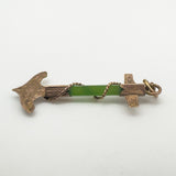 Antique nautical pendant laid flat to show gold and jade bar detail