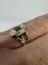 Close worn view of Georgian 9ct gold amethyst ring showing fleur de lis style shank and raised setting