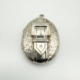 Vintage sterling silver locket with raised buckle and foliate engraving