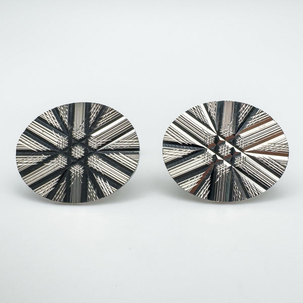 Pair of sterling silver cufflinks with diamond cut starburst pattern facing front