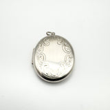 Oval sterling silver locket with foliate border and plain centre for engraving