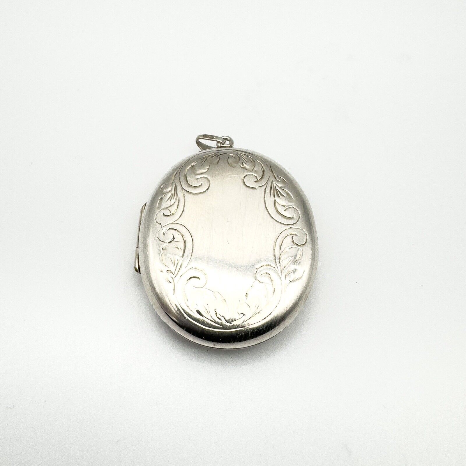 Oval sterling silver locket with foliate border and plain centre for engraving