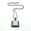 Sterling silver chain with mother of pearl and marcasite pendant laid flat, showing overall drop and proportions.