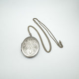 Vintage engraved oval silver locket with full 24 inch chain shown flat