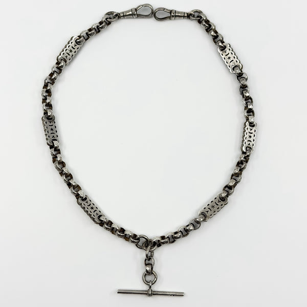 Full flat lay of an antique Victorian sterling silver Albert chain with T bar, two dog clips and pierced links