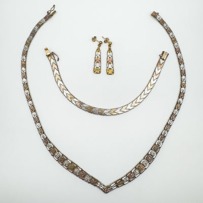 Flat lay of matching necklace, bracelet and earrings in rose, yellow and silver tones