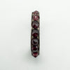 Top-down view highlighting the full row of round red garnets across the band