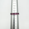 Sterling silver ring with pink rhodolite garnets shown on a metal ring sizer measuring UK size S–T