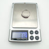 Sterling silver rhodolite garnet ring placed on digital scale showing a weight of 3.12 grams