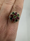 Vintage 18ct gold ruby emerald and diamond cluster ring worn on the hand, showing the colourful face