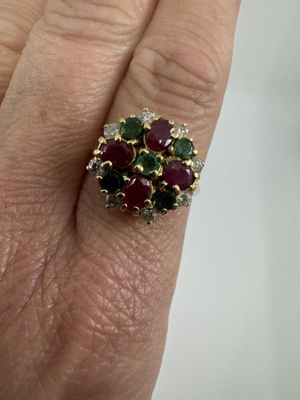 Vintage 18ct gold ruby emerald and diamond cluster ring worn on the hand, showing the colourful face