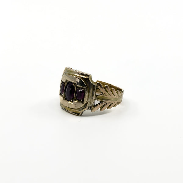 Angled side view of Georgian 9ct gold amethyst ring with openwork fleur de lis style shank