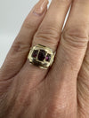 Antique Georgian amethyst trilogy ring worn on hand, showing three oval cut purple stones in gold setting