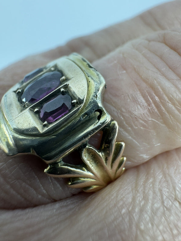 Worn side view of antique Georgian amethyst ring showing raised gold setting and fleur de lis shank