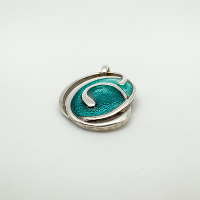 Angled view of green enamel swirly oval pendant in sterling silver