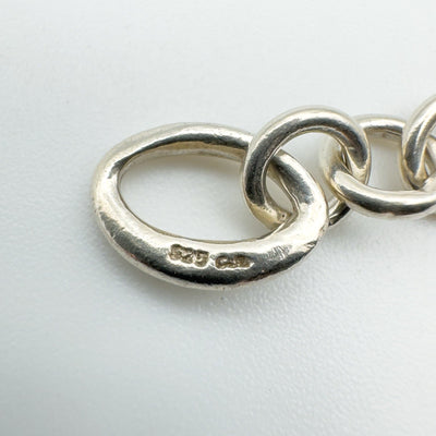 Close-up of hallmark stamped on oval link of sterling silver bracelet