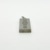 Close side view of vintage sterling silver ingot pendant with visible hallmarks and bail