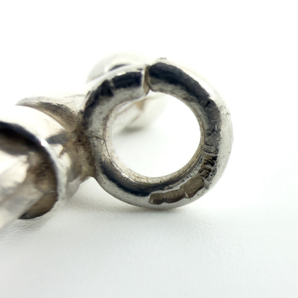 Macro photo of the hallmarks stamped on the bail ring of the sterling silver T-bar pendant.