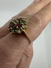 Worn side view of vintage 18ct gold gemstone cluster ring showing the raised cocktail ring setting