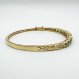 Close-up of leaf detail and push clasp on vintage gold bangle