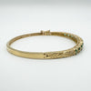 Close-up of leaf detail and push clasp on vintage gold bangle