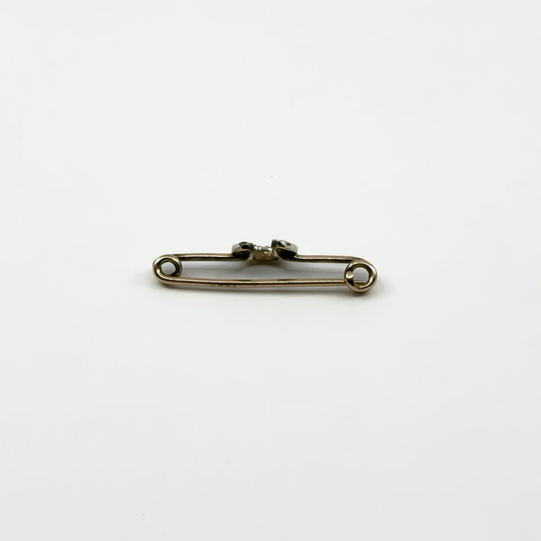 Side profile of antique horseshoe bar brooch showing gold pin and raised diamond set horseshoe