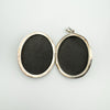 Open vintage silver locket showing two photo compartments with aged inner frame