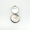 Open silver locket showing hidden mirrored interior and stamped 925
