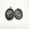 Inside of vintage silver locket with visible patina and inset chambers