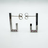 Sterling silver J hoop earrings showing pink sapphires and diamond bezel set at the base
