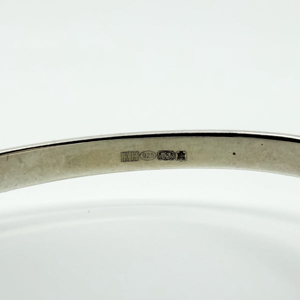 Close up of Kit Heath sterling silver bangle hallmarks showing KH and 925 stamps inside the band