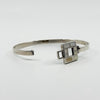 Angled view of vintage Kit Heath sterling silver bangle with square mother of pearl inlay detail