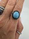 Large sterling silver turquoise and diamond halo ring shown worn on the hand