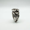 Angled close-up of leaf and 3D flower motif on chunky sterling silver ring