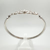 Side view of sterling silver bangle with twisted knot leading to clasp