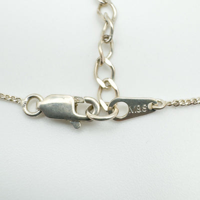 Close-up of lobster clasp with 925 stamp and M&S tag on silver chain