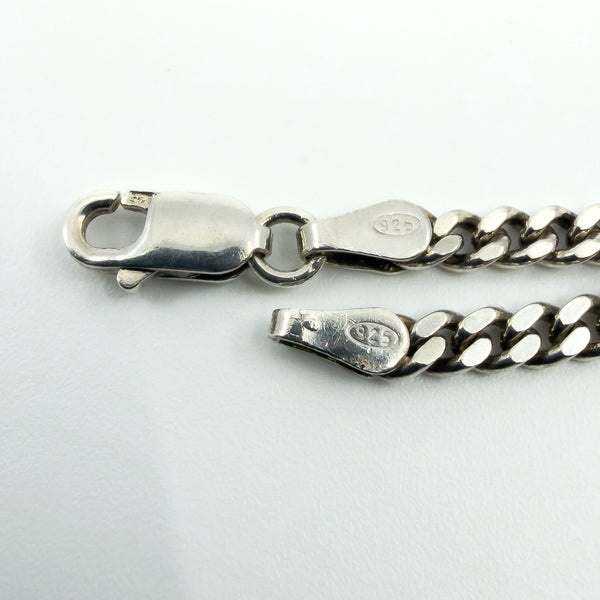 Close-up of the lobster clasp on the sterling silver curb chain, showing the 925 stamp.